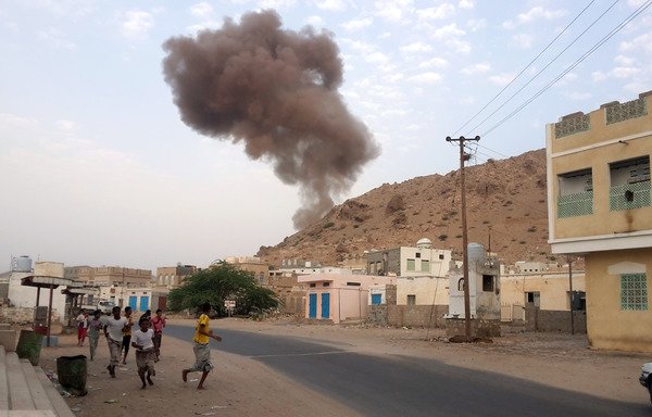 Al-Mukalla residents run for cover as smoke rises following a Monday (July 18th) al-Qaeda car bomb attack on an army checkpoint in the Hadramaut provincial capital. [Abduljabbar Bajubair/ AFP]