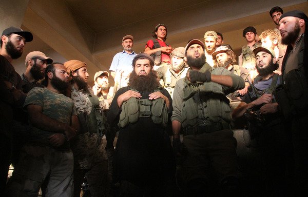 Fighters from the former Al-Nusra Front -- renamed Fateh al-Sham Front after breaking from al-Qaeda -- listen to a speech at an armament school after they recaptured two military academies and a third military position south of Aleppo on August 6th, the Syrian Observatory for Human Rights said. [Omar haj kadour / AFP]
