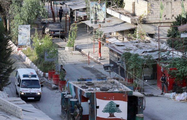 در ماه اوت سال 2015 سربازان ارتش لبنان به آمبولانسی که در حال خروج از اردوگاه آوارگان فلسطینی عین الحلوه در نزدیکی شهر بندری صیدون در جنوب لبنان است، نگاه می کنند. [محمود زیات/خبرگزاری فرانسه]