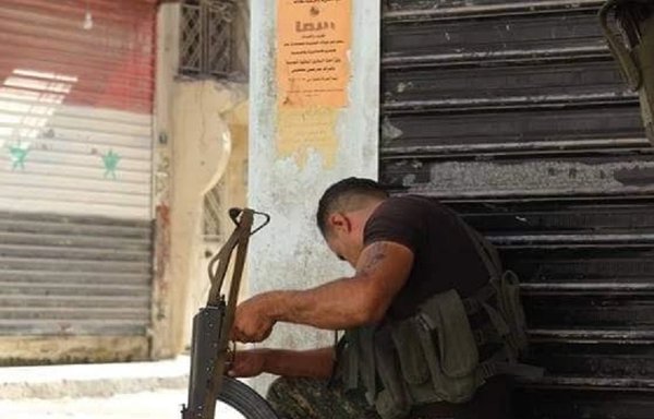 A Kurdish fighter uses a mirror to detect the movement of rival forces during fighting in the northern Syrian city of al-Hasakeh. [Photograph courtesy of Roj Ava Facebook page]