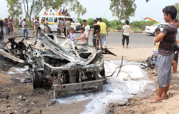 Yemenis inspect a charred vehicle following a July 15th suicide car bombing that targeted the convoy of Aden's governor. Al-Qaeda has been accused of the attack, but the 'Islamic State of Iraq and the Levant' is also active in the port city. [Saleh al-Obeidi/AFP]