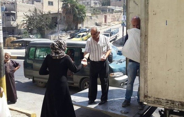 عمّال من جمعية تكية أم علي يوزعون المواد الغذائية على اللاجئين في شمال الأردن خلال عيد الأضحى. [حقوق الصورة لتكية أم علي]