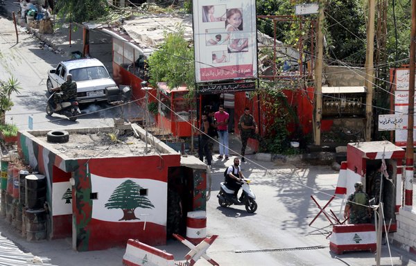 Lebanese army soldiers stand guard at the entrance of Ain al-Hilweh camp near Lebanon's southern port city of Sidon on September 22, 2016, following the arrest of Imad Yassine, a man linked to the 'Islamic State of Iraq and the Levant'. [Mahmoud Zayyat/AFP]