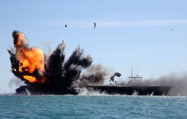 Troops from Iran's Islamic Revolutionary Guard Corps attack a naval vessel during a military drill in the Strait of Hormuz in 2015. [Hamed Jafarnejad/AFP]