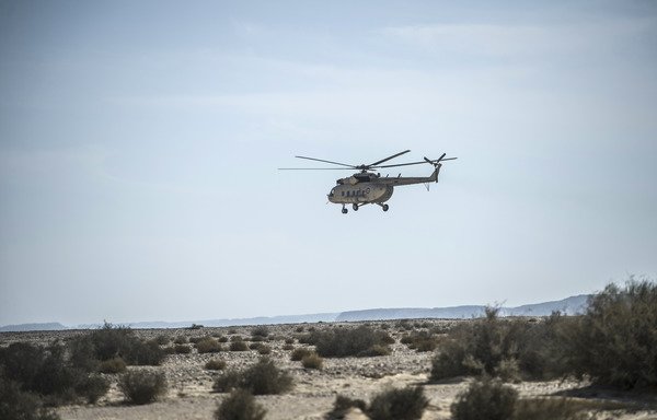 An Egyptian army helicopter flies over the crash site of a Russian airliner in Sinai's Wadi al-Zolomat on November 1st, 2015. The army recently began a new crackdown on extremists operating in the peninsula. [Khaled Desouki/AFP]