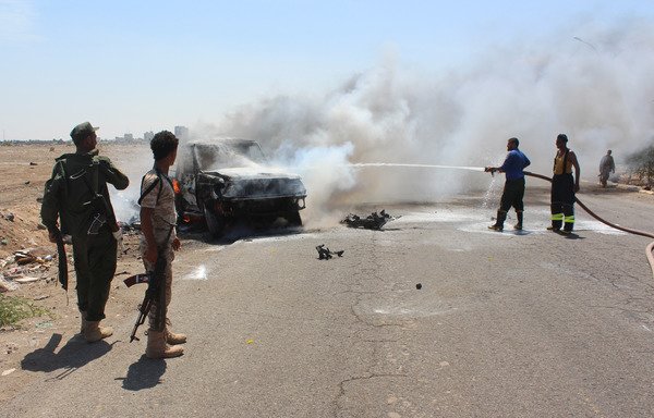 Yemeni security forces extinguish fire at a site where a bomb-laden car exploded in Aden's Mansura district in May 2016. Al-Qaeda was suspected of carrying out the attack. [Saleh al-Obeidi / AFP]