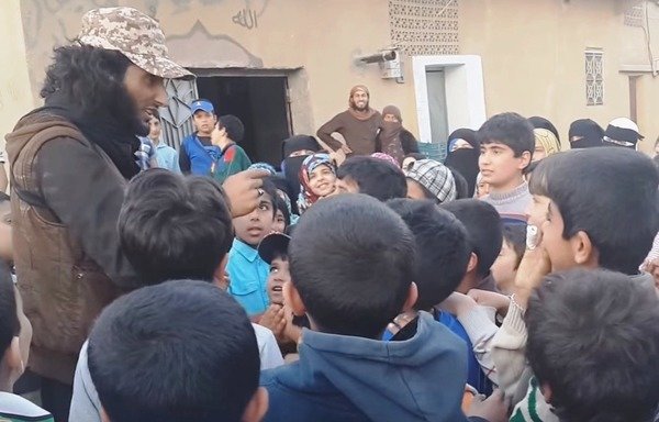 An 'Islamic State of Iraq and the Levant' fighter teaches children in Syria's al-Raqa some of the group's chants. [Photo courtesy of Syrian activist Mohammed al-Abdullah]