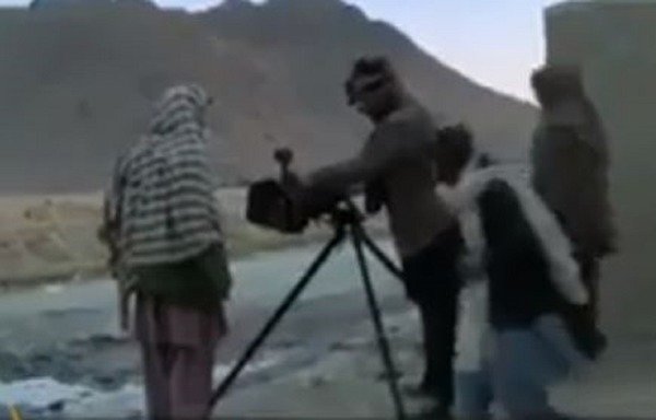 A screen grab from a YouTube video, posted by a reporter embedded with the Taliban, shows four militants attempting to fix a machine gun during an assault on an Afghan National Army base. [YouTube]