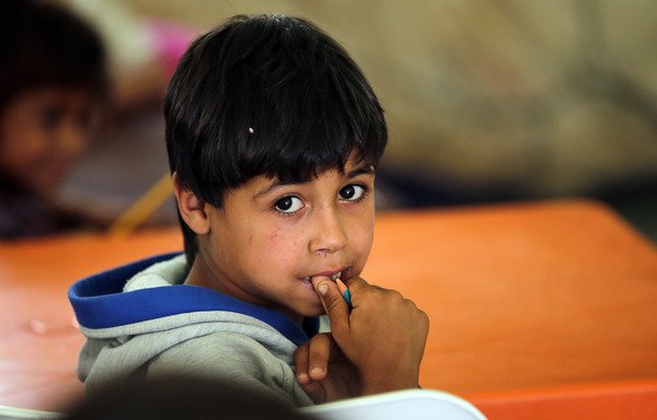 صبي سوري لاجئ يتابع دراسته في أحد مخيمات اللاجئين غير الرسمية في منطقة العريضة شمال بيروت في 15 حزيران/يونيو 2015. [جوزيف عيد/أ ف ب]