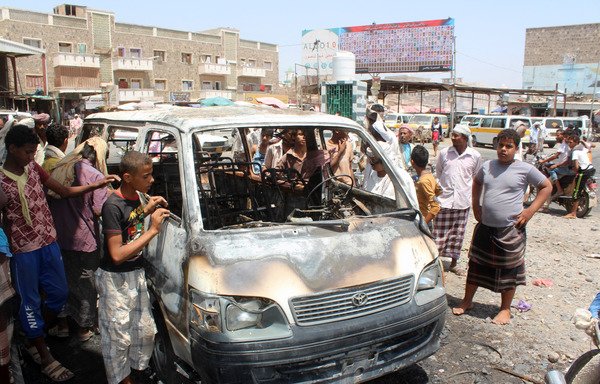 Yemeni youth gather around a burned-out vehicle in the Lahj province town of Huta on September 3rd, at the scene where a mine soldiers were taking away from the town blew up, killing three soldiers and wounding at least seven civilians. Yemeni forces retook Huta from al-Qaeda in April. [Saleh al-Obeidi/AFP]