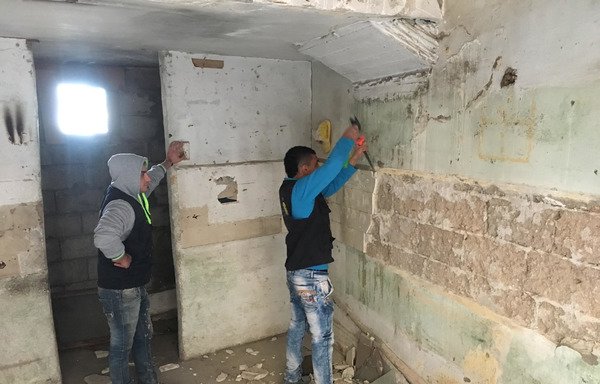 Two young men from Bab al-Tabbaneh and Jabal Mohsen participate in reconstruction work in Tripoli's Bab al-Dahab. [Photo courtesy of MARCH organisation]