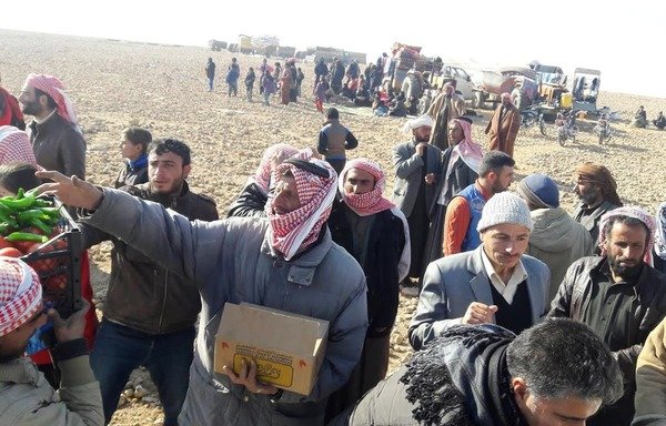 Syrian civilians from al-Raqa fleeing the 'Islamic State of Iraq and the Levant' receive aid from the Syrian Democratic Forces. [Photo courtesy of Syrian Democratic Forces]