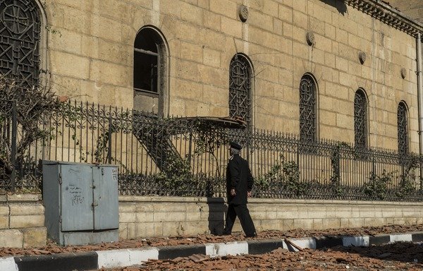An Egyptian policeman inspects the scene of a bomb explosion that targeted the St. Peter and St. Paul Coptic Orthodox Church on December 11th in Cairo's Abbasiya neighbourhood. A recent conference in Aswan called for solid legislation to stem the tide of terrorism and for stronger co-operation between security, military, political and economic state agencies. [Khaled Desouki/AFP]