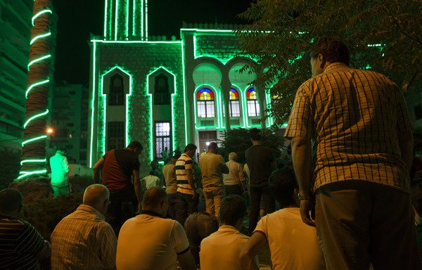 Muslim worshippers perform the evening (Isha) prayer during the holy fasting month of Ramadan on June 7th, 2016 outside al-Sadiq mosque in the Lebanese coastal city of Tripoli. [Benjamin Cremel/AFP]