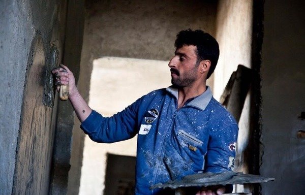 A Syrian refugee works at a construction site in Amman. Jordan has made it easier for refugees to obtain work permits, and has waived the associated fees for a limited period. [Photo from the Facebook page of Jordan Labour Watch]
