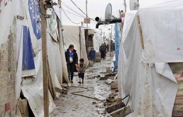 کودکان پناهجوی سوری در یک کوچه خاکی در اردوگاه پناهجویان غیررسمی در روستای دیر زنون در دره بقاع لبنان روز 31 ژانویه 2017 راه می روند. [ جوزف عید/ خبرگزاری فرانسه]