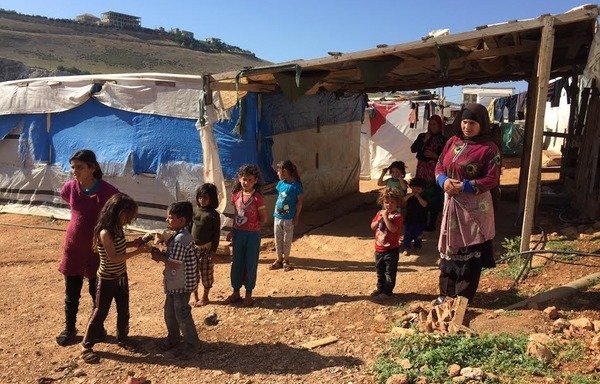 أطفال من اللاجئين السوريين خارج خيمتهم في مرج الخوخ، وهو مخيم عشوائي في جديدة مرجعيون في جنوب لبنان. [نهاد طوباليان/المشارق]