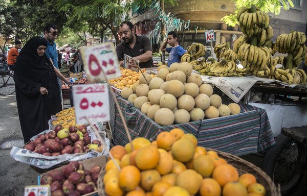 مصريون يتسوقون في سوق للفاكهة في مصر قبل 10 أيام من بدء رمضان. ويعدّ الشهر الفضيل فترة صوم خلال النهار تليه مآدب افطار غنية بتنوعها، إلا أن المصريين اضطروا إلى الحد من مشترياتهم لشهر رمضان هذا العام نتيجة اجراءات التقشف التي أدت إلى مستويات تضخم هي الأعلى خلال عقد من الزمن. [خالد الدسوقي/ أ ف ب]
