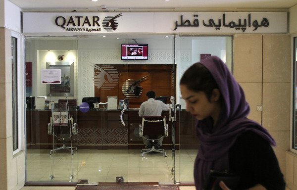 An Iranian woman walks past a Qatar Airways branch in the capital Tehran on June 6th. Saudi Arabia and allies including Egypt, the UAE and Bahrain cut diplomatic ties and transport links with Qatar on Monday, accusing the Gulf state of supporting extremism. [Atta Kenare/AFP]