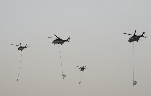 A picture taken on May 23rd shows Saudi military helicopters performing at a graduation ceremony, demonstrating counter-terrorism tactics, at the Special Forces College in Riyadh. [Fayez Nureldine/AFP]
