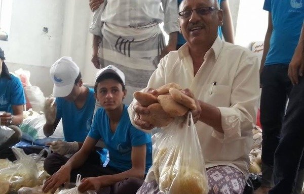 يمنيون يجمعون الطعام والخبز لتوزيعه على المحتاجين خلال رمضان في مسجد التقوى في منطقة شملان. [حقوق الصورة لعبدالله عبد الاله]