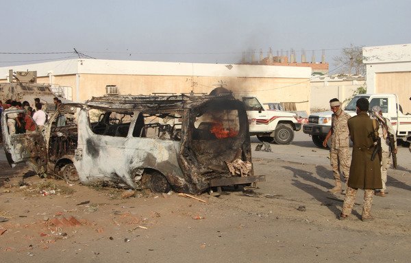 Yemenis inspect a burning vehicle following a reported suicide car bombing in the Lahj provincial capital of Huta, an al-Qaeda stronghold, on March 27th. [Saleh al-Obeidi/AFP]