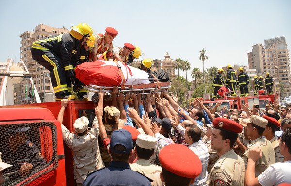 Egyptian policemen and firefighters lower the body of a soldier who was killed a day earlier in the restive Sinai Peninsula in an attack by the 'Islamic State of Iraq and Syria', during a funeral ceremony in the city of Al-Mansurah on July 8th. [Ahmad Hammad/AFP]
