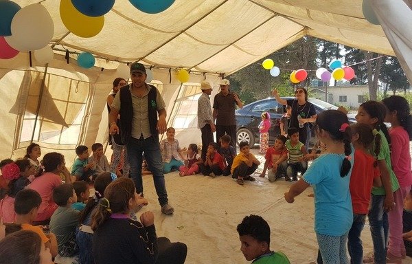 أعضاء من جميعة بيوند يقدمون للأطفال جلسة دعم نفسي بعد الحريق، داخل خيمة في البقاع بعد أن دمر حريقان مخيمات للاجئين. [حقوق الصورة لجميعة بيوند]