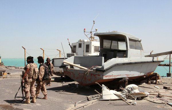 Pro-government forces walk in the port of the western Yemeni coastal town of Mokha on February 9th. Houthi militias attacked the port on July 29th with an explosive-laden vessel. [Saleh al-Obeidi/AFP]