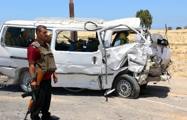 A member of the Egyptian security forces stands guard next to a damaged bus following a roadside bomb blast which wounded 20 Egyptian policemen on the outskirts of the northern Sinai provincial capital of al-Arish on July 9th, 2015. [Stringer/AFP]