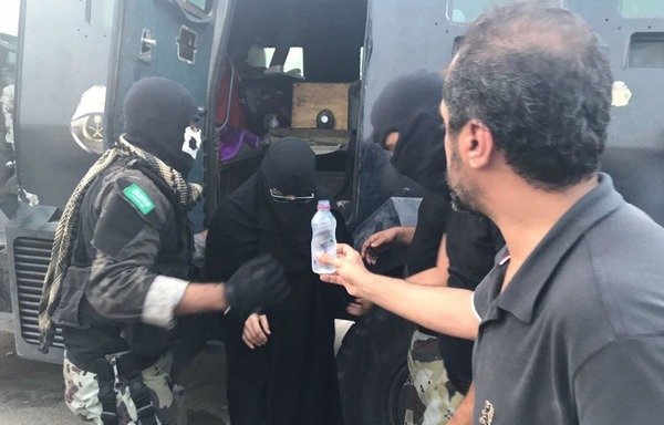 Members of the Saudi Special Forces who took part in the storming of Qatif's Almosara district assist women who were evacuated from the district. [Photo courtesy of the Saudi Press Agency]