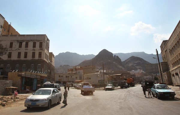 Yemenis walk down a street in the southern city of Aden in this file photo from November 29th, 2010. Reconstruction work is set to begin this week to restore houses and squares damaged in the current conflict. [Karim Sahib/AFP]
