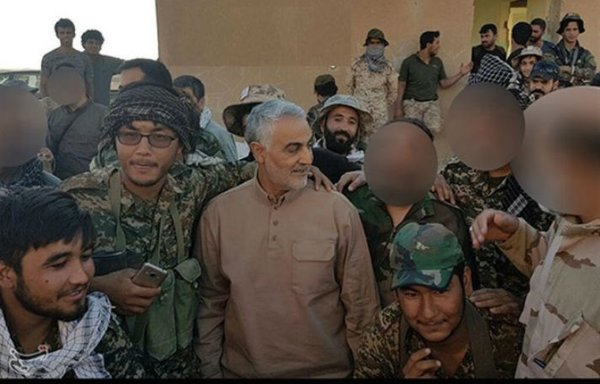 Qassem Soleimani, commander of the elite Quds Force of Iran's Islamic Revolutionary Guard Corps, is pictured here with Afghan fighters from the Fatemiyoun Brigade on the Syrian side of the Iraqi-Syrian border. [Photo circulated on pro-IRGC social media accounts]