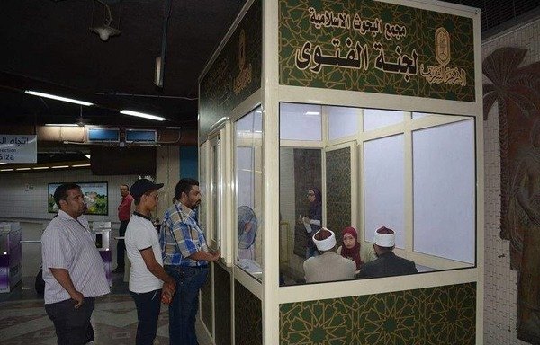 مسؤولون في الأزهر يجيبون عن أسئلة يطرحها المواطنون حول مواضيع مختلفة في كشك جديد للفتوى أقيم داخل محطة مترو الشهداء في القاهرة. [حقوق الصورة للجنة الفتوى في الأزهر]