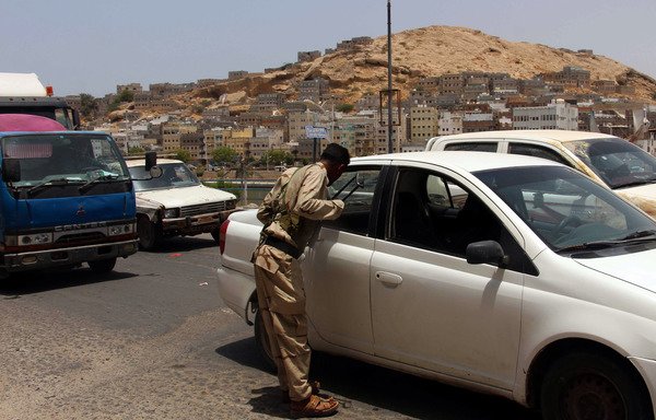 Yemeni security forces inspect vehicles at a checkpoint in al-Mukalla, the capital of Yemen's south-eastern Hadramaut province, on July 19, 2016. [Abduljabbar Bajubair/AFP]