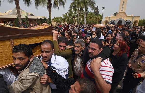 Mourners carry the coffins of victims of the April 9th blast at St. Mark's church in Alexandria during a funeral procession at the Monastery of Marmina in Borg el-Arab on April 10th. [Mohamed el-Shahed/AFP]
