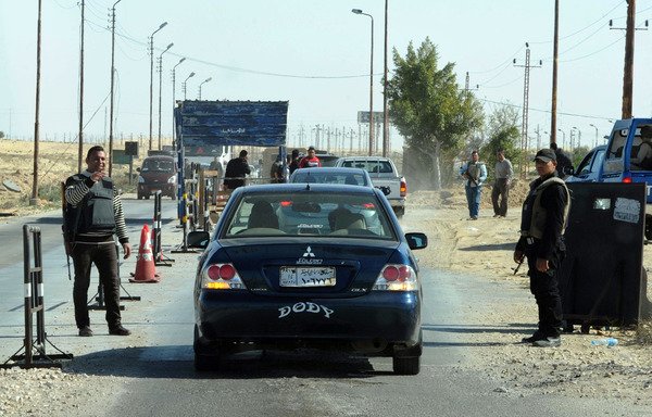 Egyptian police inspect cars at a checkpoint in North Sinai on January 31st, 2015. [Stringer/AFP]