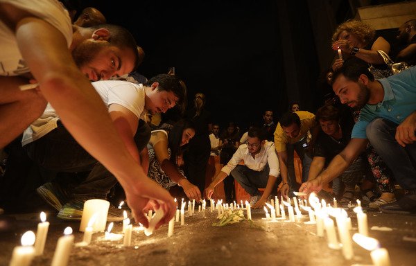 Lebanese activists hold a candlelight vigil in Beirut on August 28th, after authorities announced they had located human remains which DNA testing on Wednesday revealed belong to nine soldiers abducted and killed by the 'Islamic State of Iraq and Syria'. [Anwar Amro/AFP]