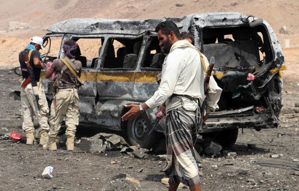 Yemeni soldiers check the scene of a car bomb attack at an army checkpoint at the entrance to the town of Hajr, located some 15 kilometres to the west of al-Mukalla, the capital of Yemen's Hadramaut province on July 18th, 2016. [Abduljabbar Bajubair/AFP]