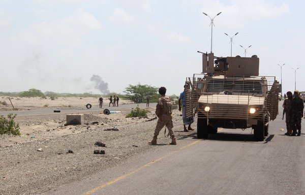 Yemeni forces stand guard as smoke billows near the entrance to Abyan province during an operation to oust al-Qaeda on April 23rd, 2016. Yemeni forces are still battling al-Qaeda in the province. [Saleh al-Obeidi/AFP]