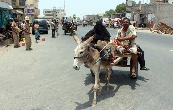 گذار یک مرد و زن یمنی سوار بر الاغ خود از کنار نیروهای دولتی یمن در زنجبار، مرکز ابین، در روز 16 اوت 2016، در پی ورود این نیروها به زنجبار به منظور بازپس گیری آن از القاعده. ورود دوباره نیروهای دولتی به ابین در روز 14 اوت در پی درگیری با عوامل القاعده که از خلاء قدرت دریمن برای گسترش حضور خود در بخشهای جنوبی و جنوب شرقی بهره برداری کرده بودند. [صالح العبیدی/ خبرگزاری فرانسه]