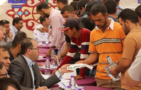 لاجئون سوريون يلتقون أرباب عمل في مركز التشغيل في مخيم الزعتري في 4 تشرين الأول/أكتوبر. [خليل مزرعاوي/أ ف ب]