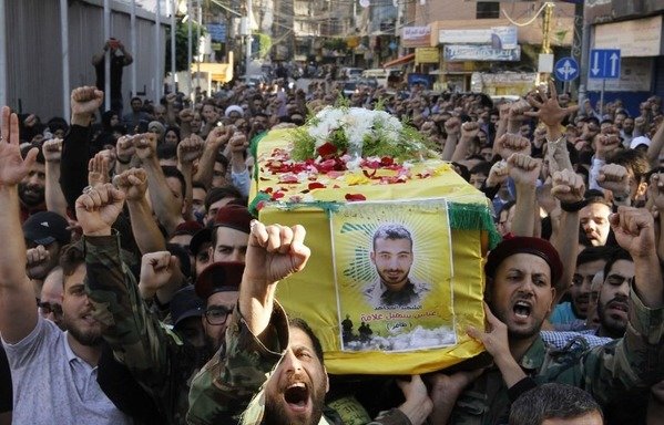Hizbullah fighters and supporters attend the funeral of a commander, who died in combat in Syria, in a southern suburb of Beirut on May 29th. [Stringer/AFP]