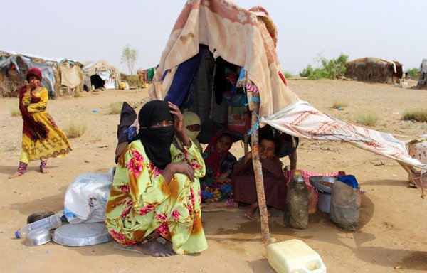 Displaced Yemenis who fled fighting in the Harad area sit under a makeshift shelter at a camp for internally displaced persons in Abs district of Hajjah province on July 23rd. [STRINGER/AFP]