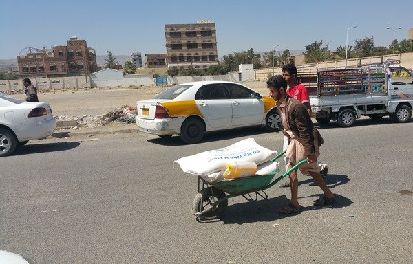 A Yemeni man transports food aid through the streets of Sanaa. [Faisal Darem/Al-Mashareq]