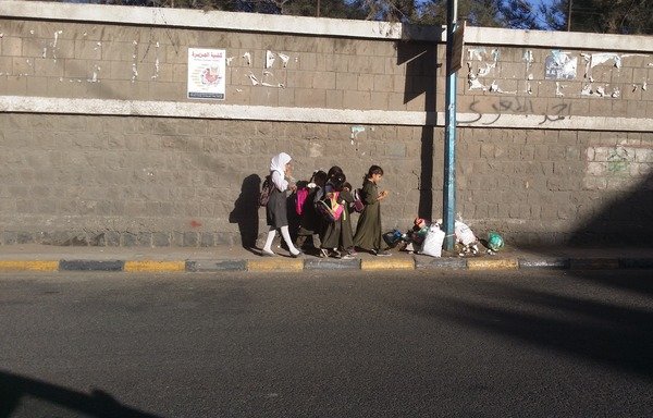 فتيات يمنيات في طريقهن إلى المنزل بعد الدوام المدرسي في صنعاء. في حين لا تزال العديد من المدارس مقاعدها فارغة، تواجه المدارس في صنعاء ازدحاماً طلابياً نتيجة تدفق العائلات النازحة. [حقوق الصورة لمحمد عبدالله]