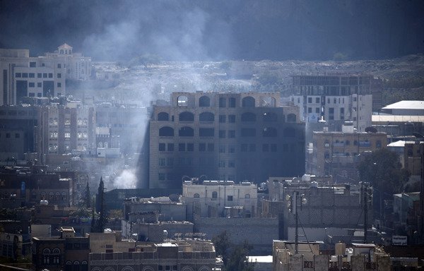 Smoke billows behind a building in Sanaa on December 3rd during clashes between the Houthis and supporters of Yemeni ex-president Ali Abdullah Saleh. Saleh was reported killed the following day. [Mohammed Huwais/AFP]