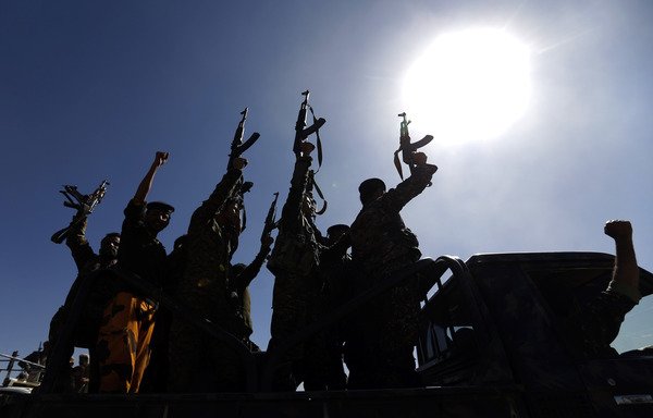 Newly recruited Houthi fighters chant slogans as they ride a military vehicle during a gathering in Sanaa to mobilise more fighters to battlefronts to fight Yemeni forces on January 3rd. [Mohammed Huwais/AFP]