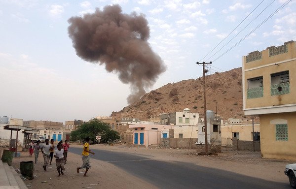 Yemenis run for cover as smoke rises following a car bomb attack at an army checkpoint at the entrance to the town of Hajr, located to the west of al-Mukalla, the capital of Hadramaut province on July 18th, 2016. [Abdul Jabbar Bajubair/AFP]