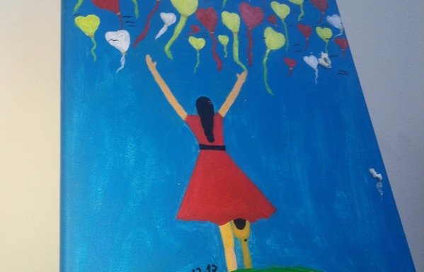 لوحة للاجئة السورية إيمان الشياب تظهر فتاة مبتورة الأطراف في ثوب أحمر، تقف على خلفية سماء زرقاء مليئة بالبالونات على شكل قلوب. [نور الصالح/المشارق]